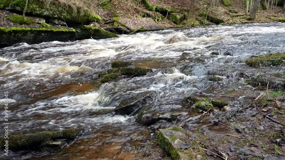 Fast water flow in rocky river. River flowing over stones. Fast water flow in rocky river. River flowing over stones.