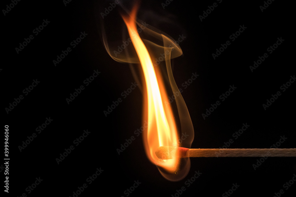 Kunstvoll geschwungene Flamme und Qualm eines angezündeten Streichholz vor schwarzem Hintergrund
