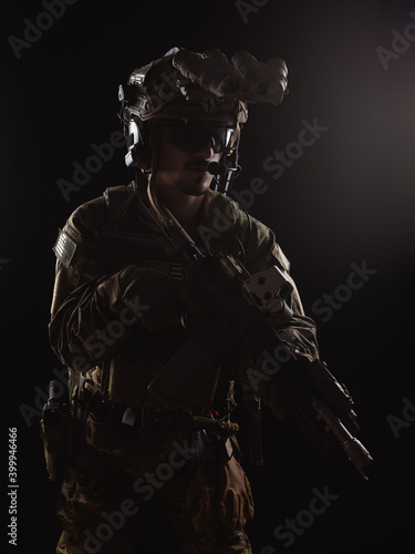 Delta Force soldier, US army special forces. Combat application group, Army compartmented element operator - Tier 1. Portrait on a black backdrop with rifle and night vision. photo