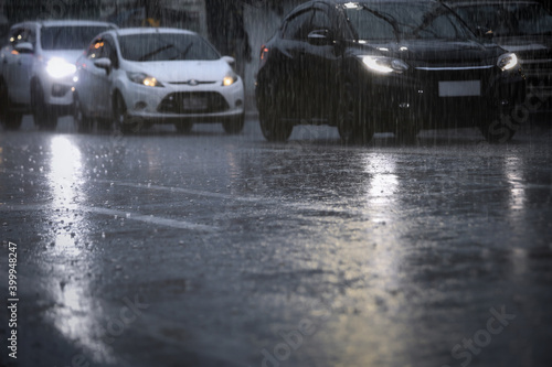 Blurry cars in a long queue on the busy city street during hard rain fall at night.Selective focus and shallow depth of field composition.