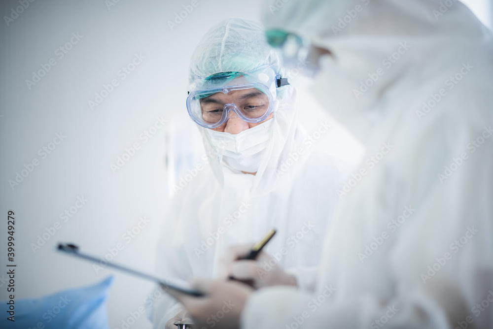 Doctors are treating patients infected with COVID-19, during examination in hospital room and wearing visor as safety precaution against coronavirus. Medical control for infections, disease Doctors are treating patients infected with COVID-19, during examination in hospital room and wearing visor as safety precaution against coronavirus. Medical control for infections, disease