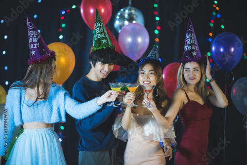 Cheerful group of people with drinks in hands celebrating new 2021 year