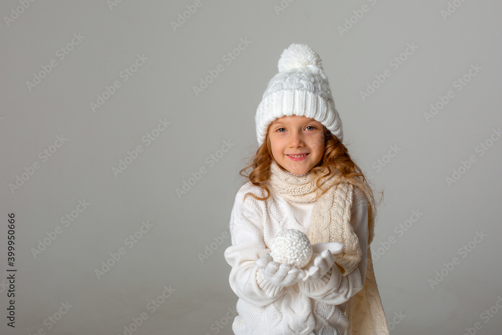 cute little girl dressed in a winter white hat and clothes holding a snowball on a white background cute little girl dressed in a winter white hat and clothes holding a snowball on a white background