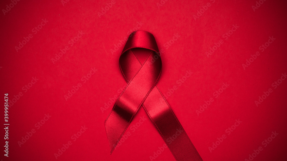 Infection symbol. Red ribbon symbol in hiv world day on dark red background. Awareness aids and cancer. Healthcare and medical concept. - obrazy, fototapety, plakaty 