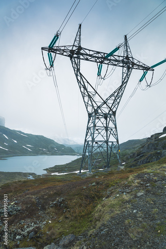 Green electricity produced by water power plant transported via big transportation masts up in a mountain area.