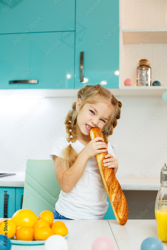 Portrait of a little blonde girl biting a fresh baguette Portrait of a little blonde girl biting a fresh baguette