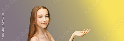 Cosmetology concept. Skin care product. Female portrait. Young girl showing face mask. Grey background. Copyspace. Facial lifting treatment. Dermatology beauty model. Happy smile