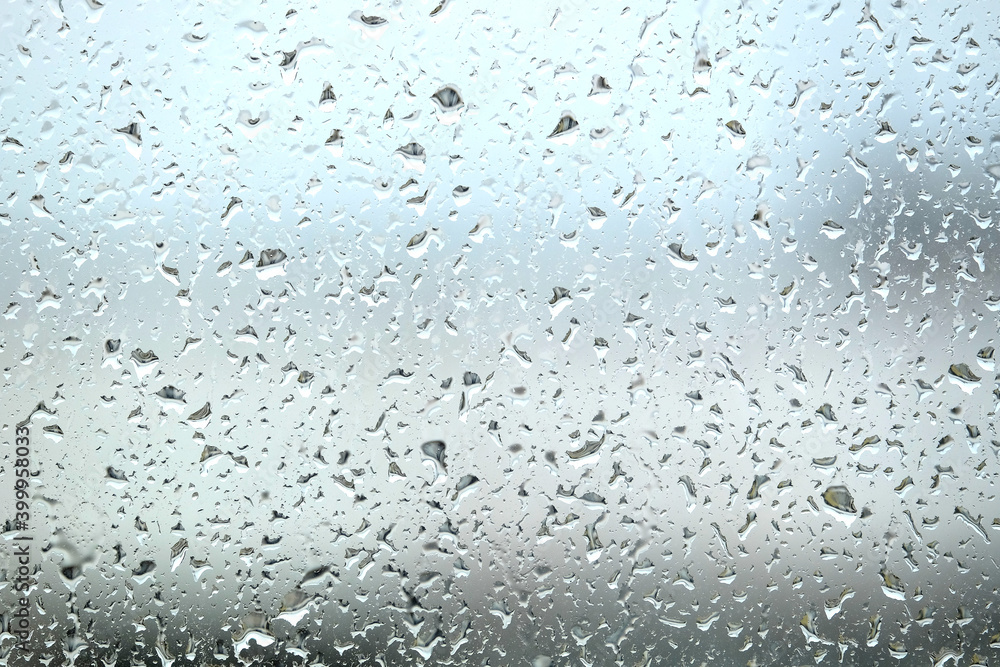 Background with rain droplets on window glass on gloomy autumn day on blur gray background close up Background with rain droplets on window glass on gloomy autumn day on blur gray background close up