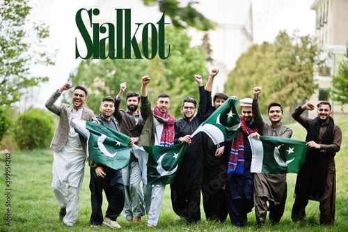 Sialkot city. Group of pakistani man wearing traditional clothes with national flags. Biggest cities of Pakistan concept. photo