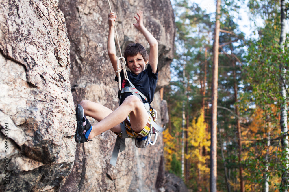 cute teen kid climbing on rock with insurance, lifestyle sport people concept