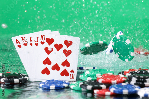Royal Flush combination under the water drops against green background. Online gambling. Betting. Gambling addiction.