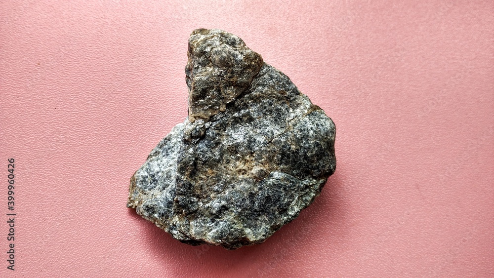 Schist Mica metamorphic rock foliated structure on pink background. With quartz, muscovite, garnet, chlorite, calcite, apatite on Melange tectonic zone in Karangsambung, Indonesia. Ophiolite area Schist Mica metamorphic rock foliated structure on pink background. With quartz, muscovite, garnet, chlorite, calcite, apatite on Melange tectonic zone in Karangsambung, Indonesia. Ophiolite area