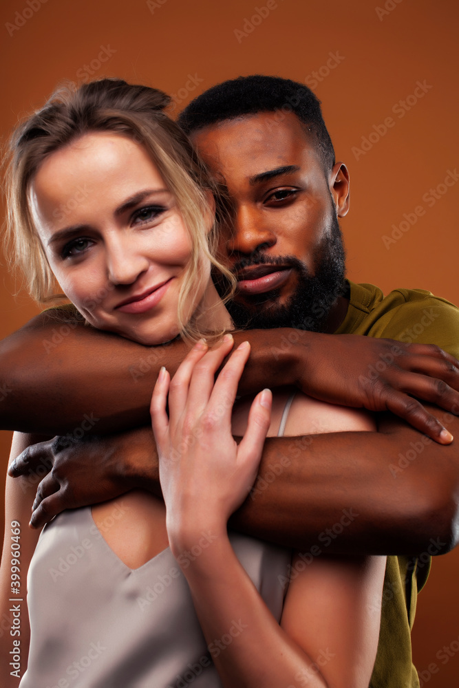 oung pretty couple diverse races together posing sensitive on brown background, lifestyle people concept oung pretty couple diverse races together posing sensitive on brown background, lifestyle people concept