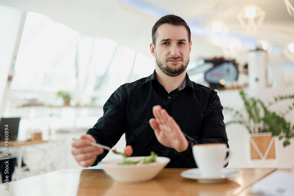 I don't want eat this Young man with beard is upset with the dish the waiter served him. Man is disappointed in his favorite restaurant. Bad food and service concept. Restaurant on the background. I don't want eat this Young man with beard is upset with the dish the waiter served him. Man is disappointed in his favorite restaurant. Bad food and service concept. Restaurant on the background.