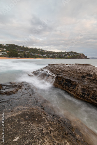 Water flowing through the big rocks at Whale Beach coastline, Sydney, Australia.