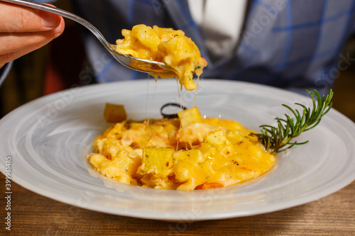 Pasta e patate con pomodoro, patate a quadratini e provola affumicata filante photo