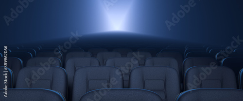 Empty rows of seats in the cinema. Working movie projector in background.