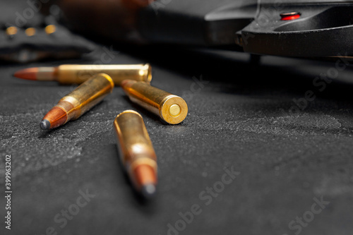 Close up of hunting shotgun and cartridges on dark grey background
