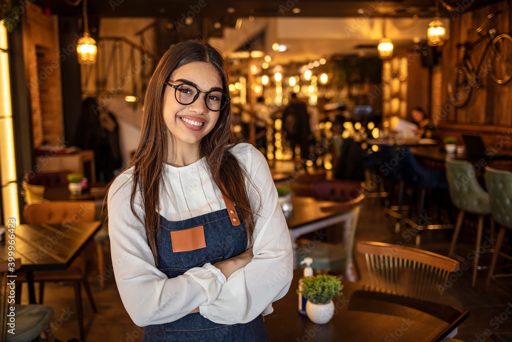 Portrait of a confident young woman standing in the doorway of a coffee shop. Portrait of Smiling cafeteria owner. Small business owner at entrance looking at camera