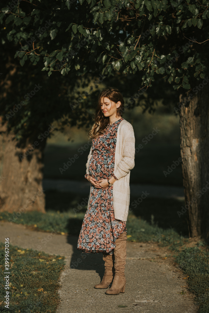 Beautiful pregnant girl wearing dress with flowers Beautiful pregnant girl wearing dress with flowers
