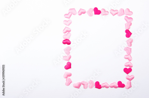 Frame made of small pink hearts on the white background photo