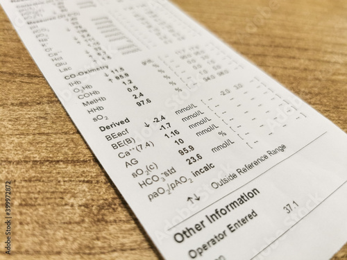 Arterial blood gas (Astrup) analysis results on printed on paper. Defocused, blurry image with focus on Base Excess values.