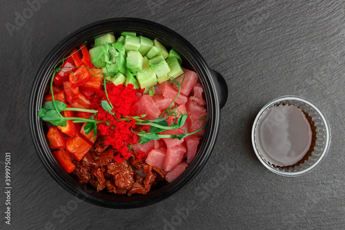 Bowl of rice, fish, avocado, tomayo and bell pepper