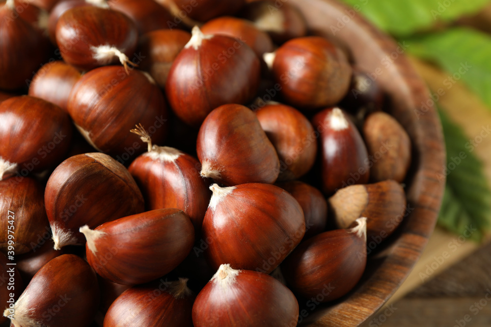 Fresh sweet edible chestnuts in wooden bowl, closeup Fresh sweet edible chestnuts in wooden bowl, closeup