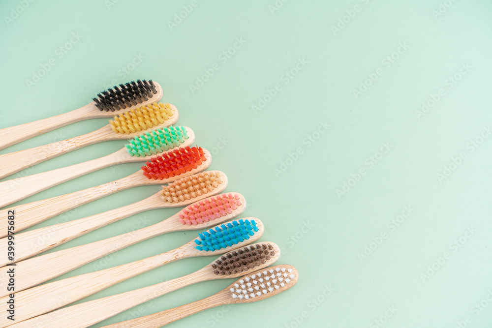 A set of Eco-friendly antibacterial toothbrushes made of bamboo wood on a light green background. Environmental care trends A set of Eco-friendly antibacterial toothbrushes made of bamboo wood on a light green background. Environmental care trends