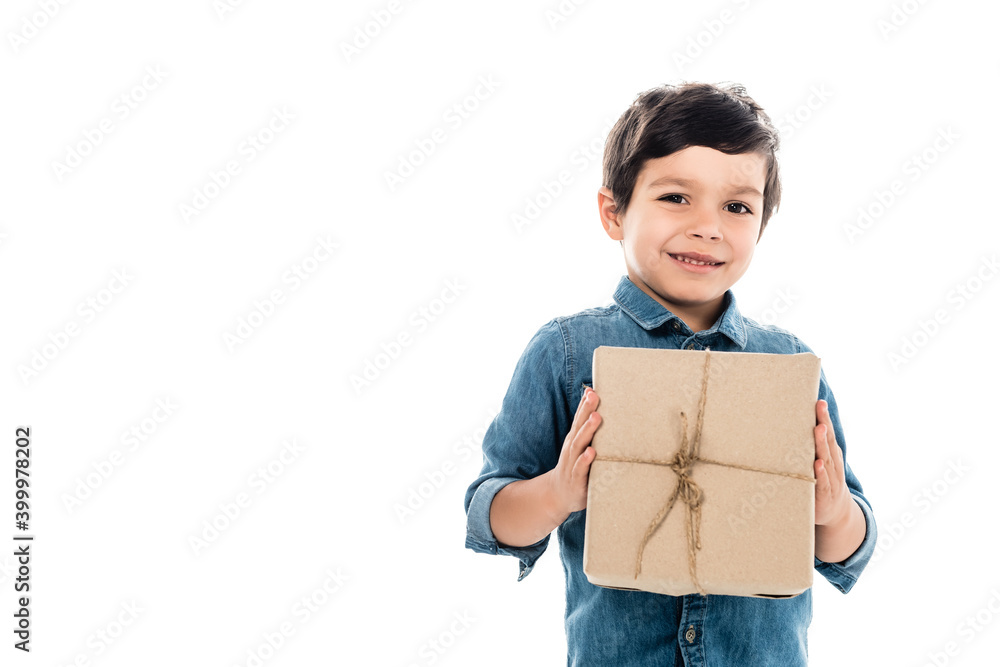 smiling kid in denim shirt holding gift box while looking at camera isolated on white smiling kid in denim shirt holding gift box while looking at camera isolated on white