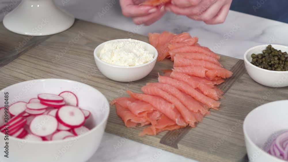 Step by step. Assembling bagel brunch board with smoked salmon and fresh vegetables. Step by step. Assembling bagel brunch board with smoked salmon and fresh vegetables.
