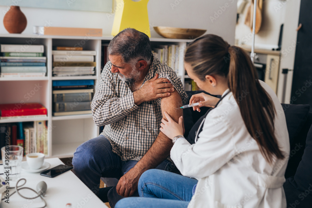man receives vaccine. home doctor concept man receives vaccine. home doctor concept