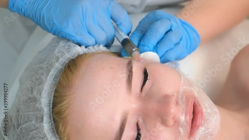 PRP therapy in beauty clinic. Cosmetologist doing injections of blood plasma to womans face to cure problem skin, closeup top view. Treatment of skin in cosmetology for young female. photo