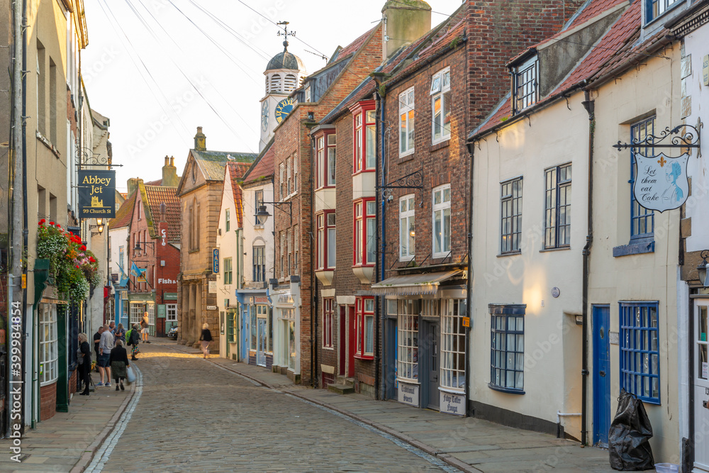View of shops on traditional cobbled street in historic town centre, Whitby, Yorkshire, England View of shops on traditional cobbled street in historic town centre, Whitby, Yorkshire, England
