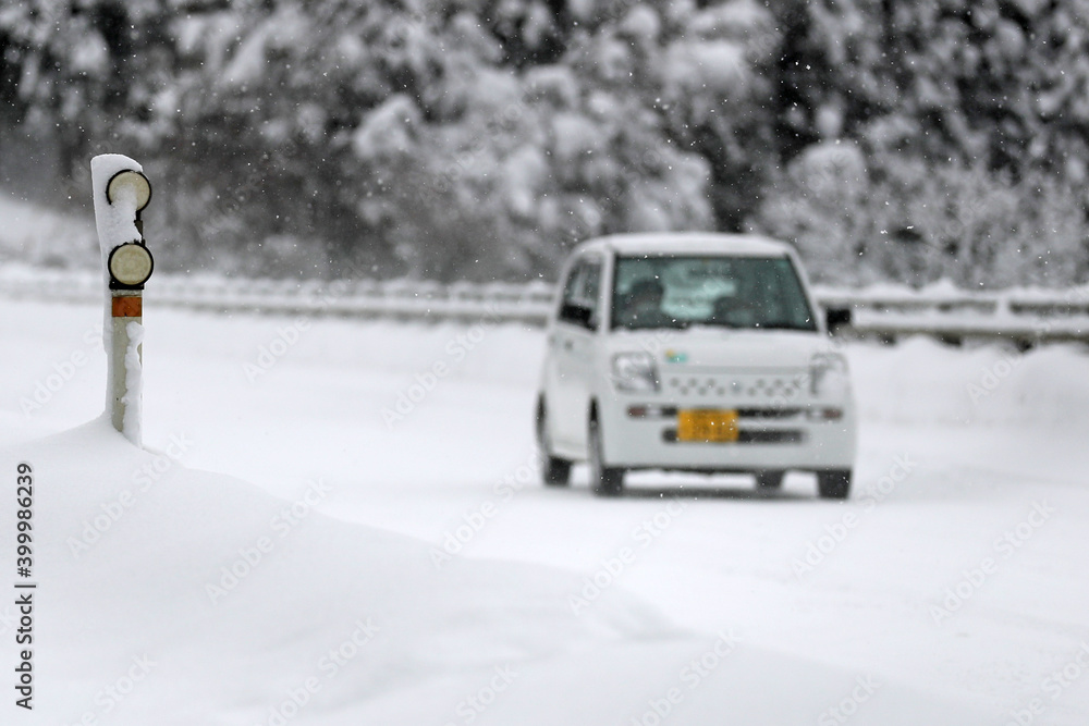 Fototapeta premium 大雪の中を走る自動車（豪雪地帯の冬）