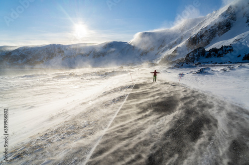 Man rejoices on icy empty road along Barents Sea during the Arctic windstorm, Berlevag, Varanger Peninsula, Finnmark photo