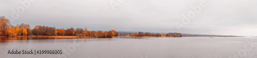 Beautiful autumn misty lake and forest wild landscape panorama. Autumn forest and lake background.