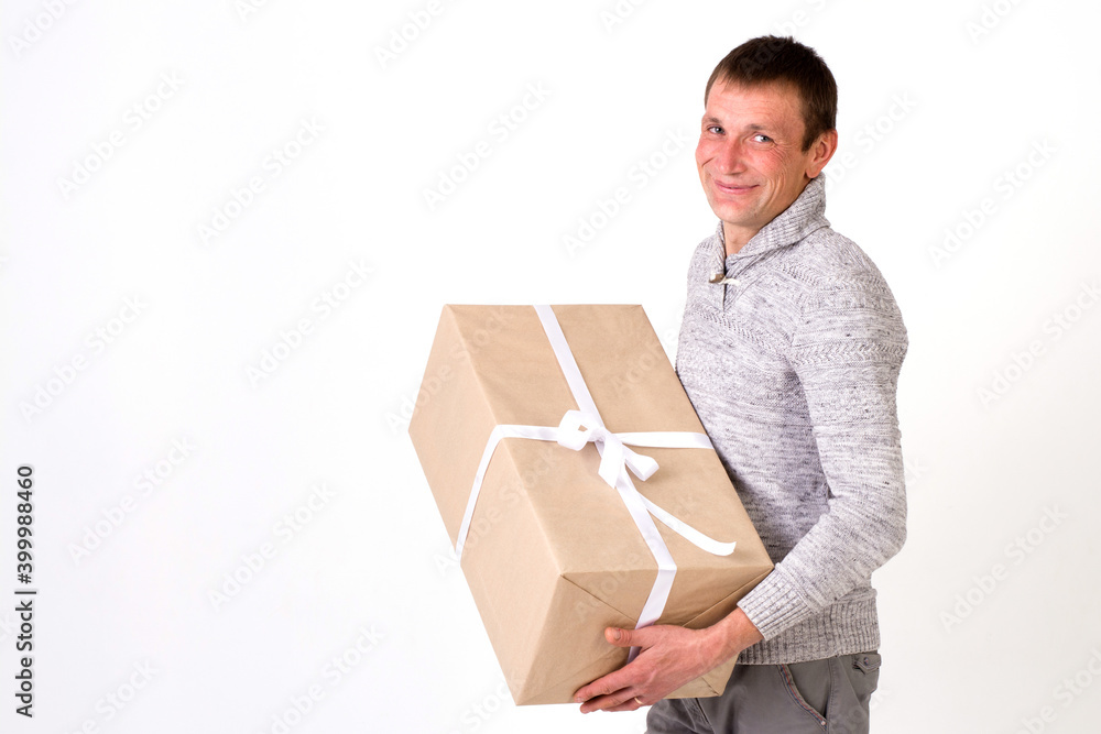 Smiling handsome man in sweater with big gift on white background Smiling handsome man in sweater with big gift on white background