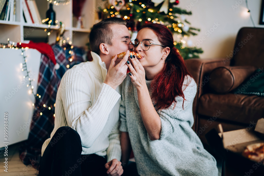 Beautiful pleased couple eating pizza on Christmas day Beautiful pleased couple eating pizza on Christmas day
