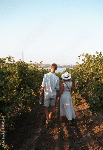 Couple with glasses drinks wine in vineyaed photo