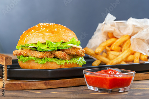 Hamburger with chicken nuggets and french fries on plate.