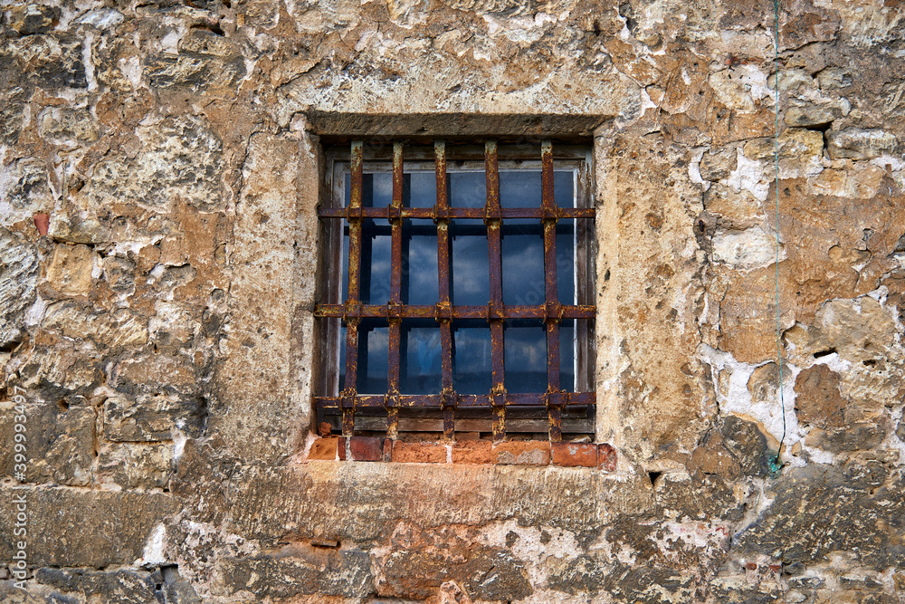 An old window in the castle with a rusty steel grate