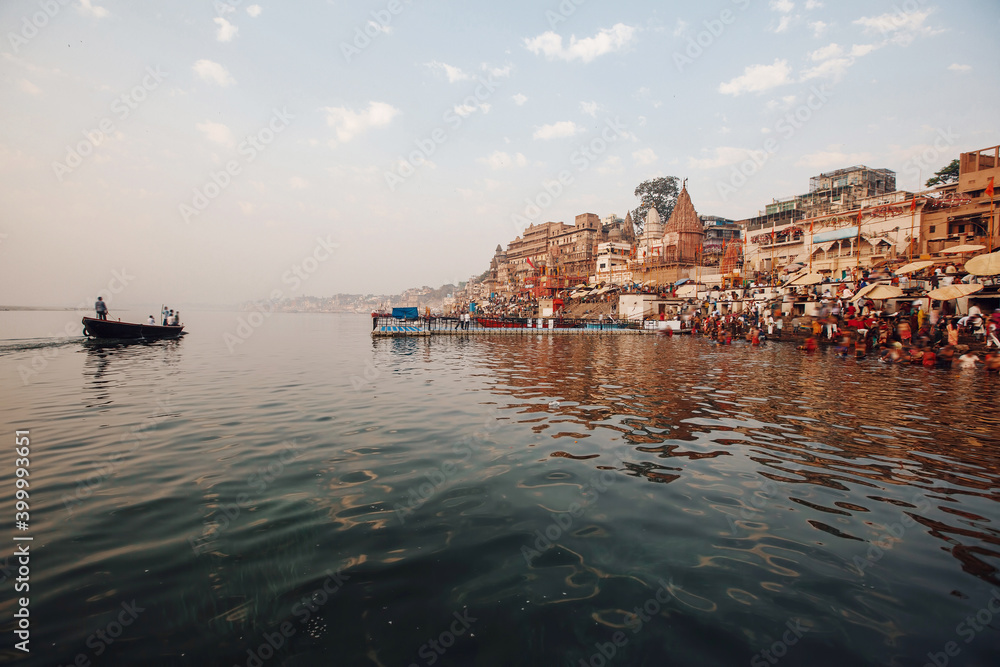 Boat on Ganga river and Varanasi ghats morning view with buildings and people