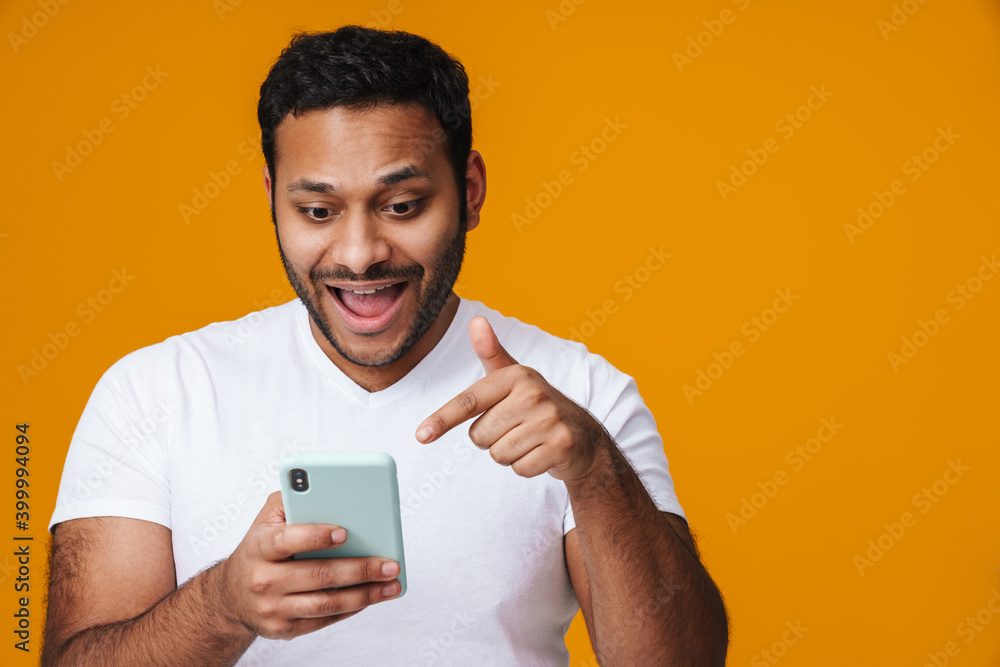 © Drobot Dean - Asian excited man holding and pointing finger at mobile phone © Drobot Dean - Asian excited man holding and pointing finger at mobile phone