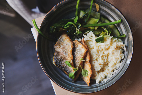 Healthy dish made of fish fillet, creamy rice and zucchini. Modern style asian cuisine. Dish on the table.