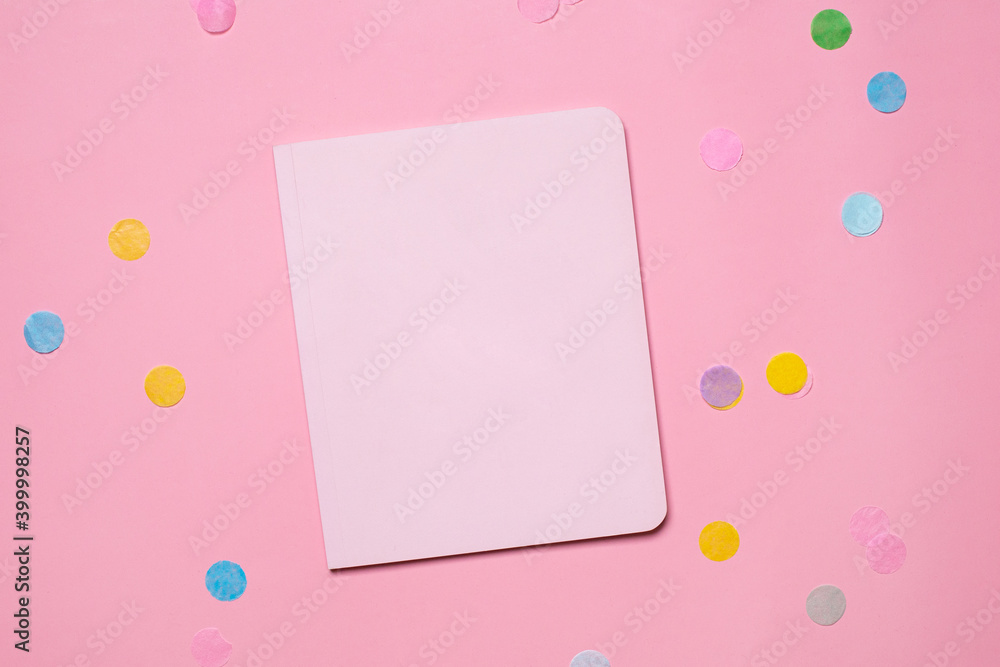 Paper pastel notebook on pink background with colorful confetti
