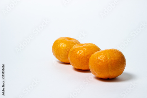 Tangerines on a white background. Citrus fruit. Three tangerines lie next to each other