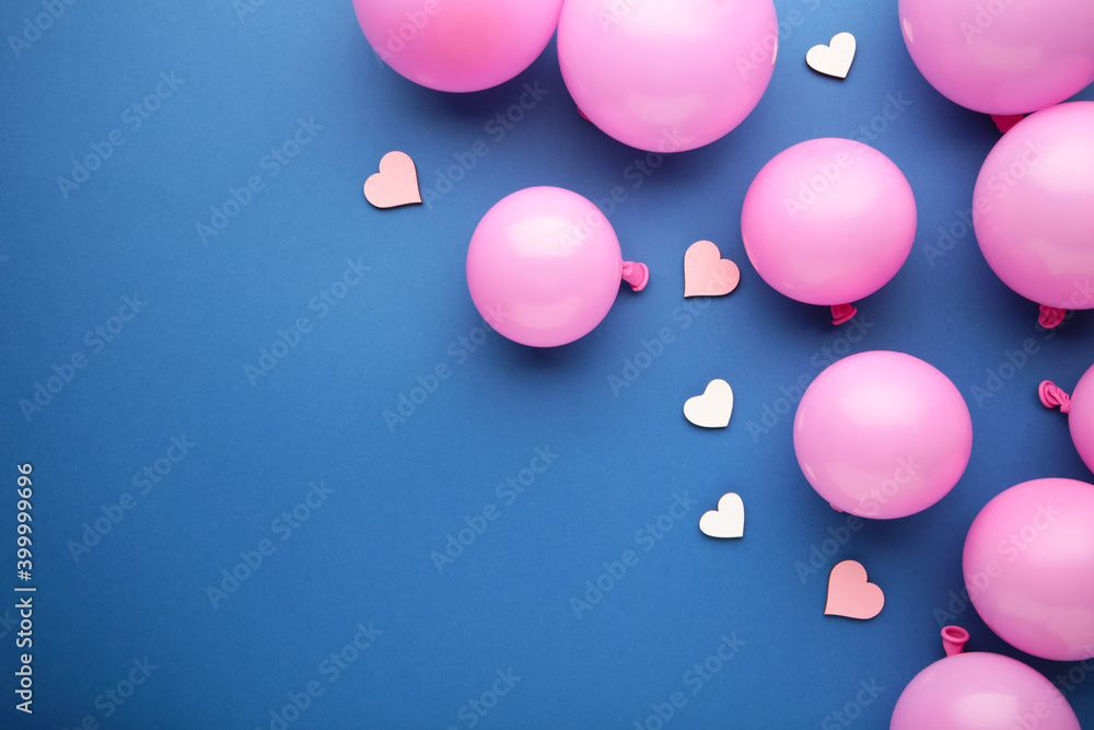 Pink pastel party balloons and pink heart on blue background with copy space for text. Valentine day.