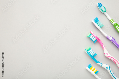 Toothbrushes on grey background with copy space.