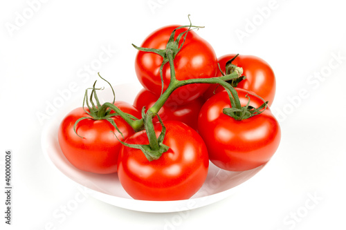 juicy ripe tomatoes on a white plate close up